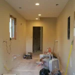 Early construction phase of Highland & Co. Acres shipping container home interior showing drywall and electrical work in progress